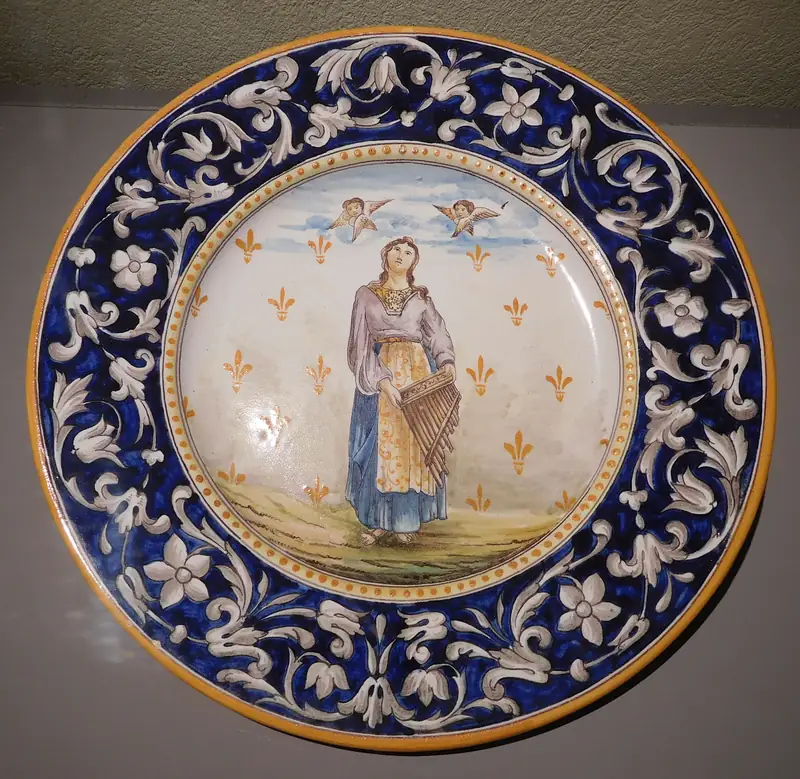 Plat en faïence de Nevers à large bord bleu orné, sainte Cécile au centre