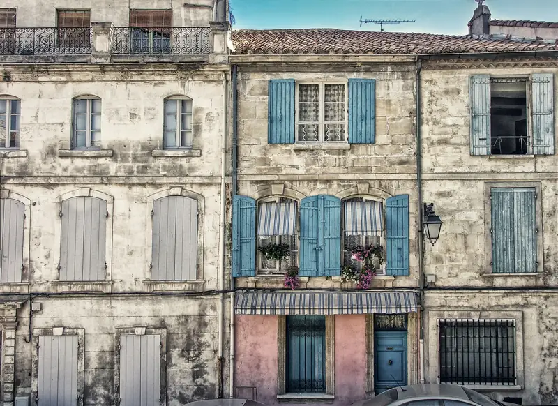 Façades anciennes en pierre aux volets bleus et gris